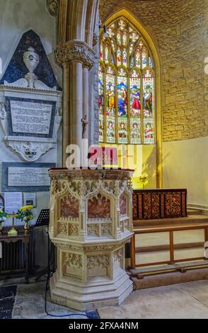 Pulpito di pietra intagliato intricately e vetrata nella chiesa di St Lawrence in Hungerford, una città di mercato in Berkshire, Inghilterra sud-occidentale Foto Stock