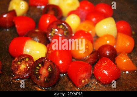 Primo piano di pomodori ciliegini multicolore frittura in olio. Foto Stock