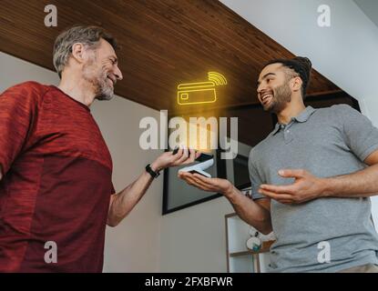 Paziente che paga tramite telefono cellulare alla pratica medica Foto Stock