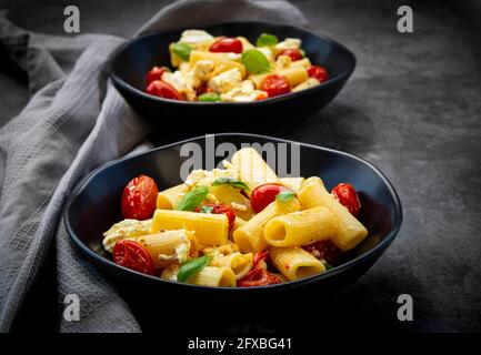 Rigatoni con pomodori al forno, feta e basilico Foto Stock