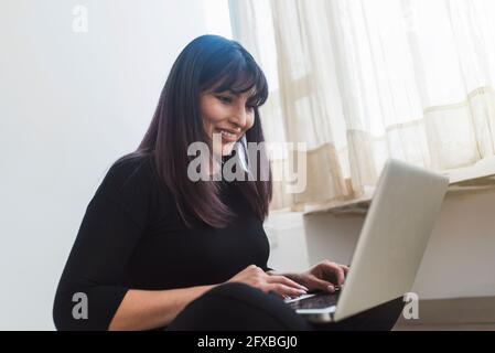 Quito, Ecuador primo piano di donna che lavora su computer portatile e smartphone Foto Stock