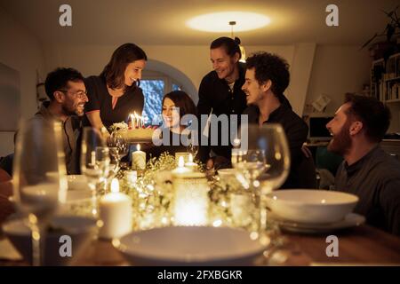Felici amici che festeggiano il compleanno di una femmina fritta a casa Foto Stock