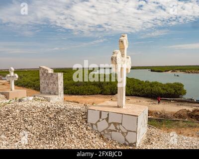 Joal-Fadiouth, Afrika - Jan, 2019: Croce cattolica su una tomba in un cimitero misto musulmano-cristiano. La città e il comune di Joal-Fadiouth nel Thi Foto Stock