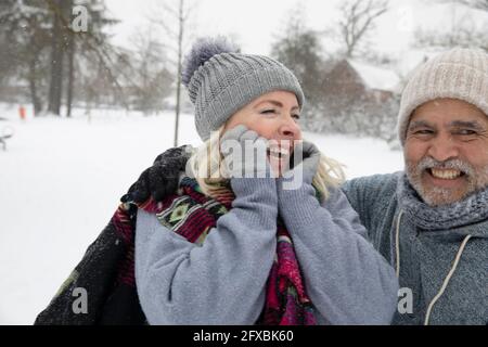 Donna allegra e uomo in abiti caldi al parco durante l'inverno Foto Stock