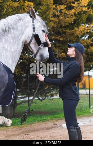 Donna che accarezzava il cavallo sul sentiero Foto Stock