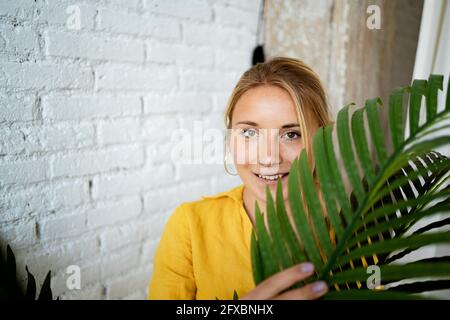 Bella donna che tiene la pianta a casa Foto Stock