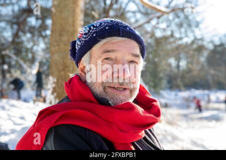 Uomo anziano che indossa una sciarpa rossa durante l'inverno Foto Stock