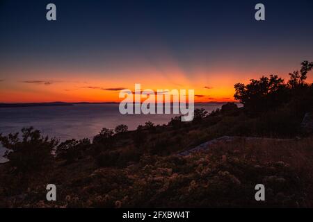 Tramonto sul mare Adriatico con cielo drammatico a Omis, Dalmazia, Croazia Foto Stock