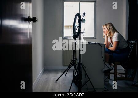 Modello di moda femminile che registra attraverso il telefono cellulare in studio Foto Stock