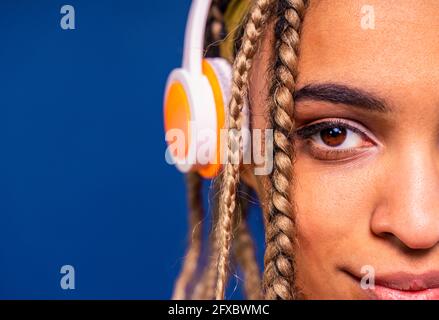 Donna sorridente intrecciata con cuffie Foto Stock