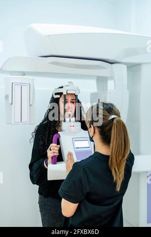 Dentista femminile che prende radiografia dentale del paziente in clinica Foto Stock