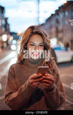 Bella donna utilizzando il telefono cellulare Foto Stock