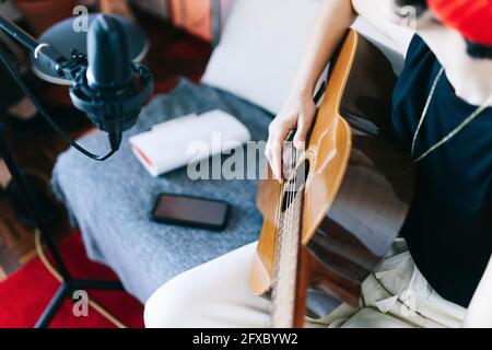 Musicista femminile che suona la chitarra in studio Foto Stock