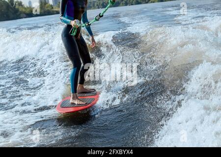 Bassa sezione di wakesurf donna nel fiume Moskva Foto Stock