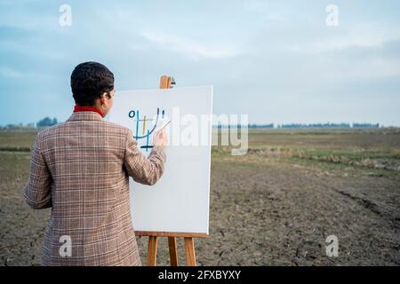 Giovane donna pittura di fronte al cielo Foto Stock