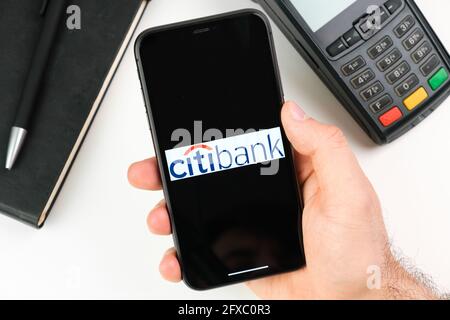 Il logo Citi Bank sullo schermo nero dello smartphone in mans Hand sullo sfondo del terminale di pagamento, maggio 2021, San Francisco, USA Foto Stock