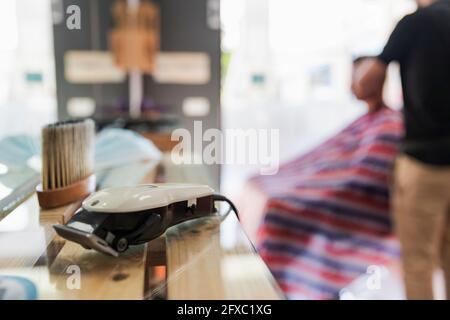 Spazzola per barbiere e macchina per il taglio dei capelli al banco del salone Foto Stock