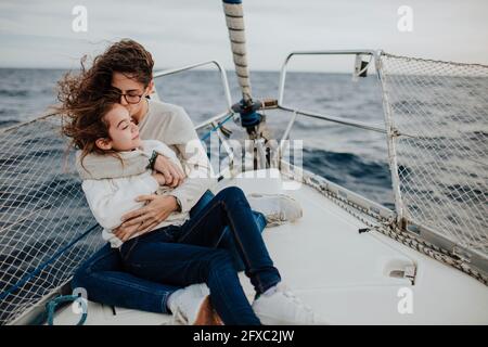 Mamma e figlia sorridenti che si divertono in vacanza in barca a vela Foto Stock