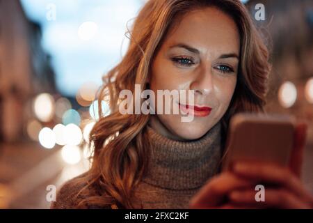 Donna bionda che usa lo smartphone Foto Stock