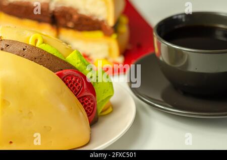 Pezzo della torta Burger, Madeira e torta stratificata di spugna di cioccolato, riempito con glassa ricoperta di glassa morbida e decorazioni di zucchero commestibile, torta i Foto Stock