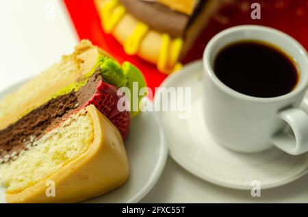 Pezzo della torta Burger, Madeira e torta stratificata di spugna di cioccolato, riempito con glassa ricoperta di glassa morbida e decorazioni di zucchero commestibile, torta i Foto Stock