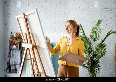 Donna in abbigliamento casual pittura a casa Foto Stock