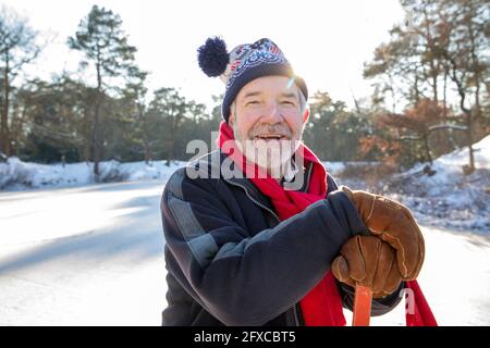 Uomo con cappello a maglia sulla neve durante il giorno di sole Foto stock  - Alamy