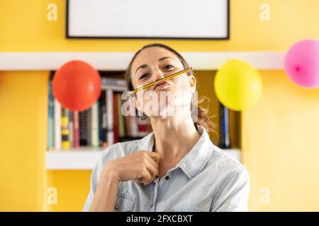 Donna mid adulta con labbra a dardo a casa Foto Stock