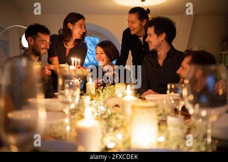 Felice uomo e donne che godono di festa di compleanno a casa Foto Stock