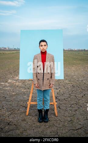 Donna in piedi di fronte alla pittura sul campo Foto Stock