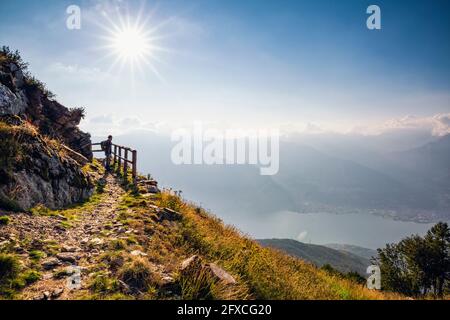 Italia, Lombardia, Hiker sul Monte Legnoncino guardando sul Lago di Como Foto Stock