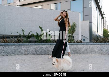 Giovane donna che cammina con il cane sul sentiero Foto Stock