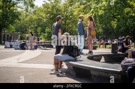 Persone mascherate e senza maschera a Washington Square Park a New York martedì 25 maggio 2021. New York ha rilassato mandati maschera permettendo la maggior parte delle attività all'aperto di essere senza maschera così come molti ambienti interni, con avvertenze. (© Richard B. Levine) Foto Stock