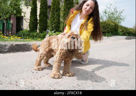 Giovane bella ragazza che cammina il cane in una giornata di sole Foto Stock