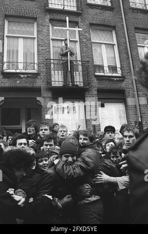 La polizia evacuare l'edificio nel quartiere di Staatsliedenbuurt; spingere le parti di fronte alla porta mentre squatter con croce è in piedi sul balcone, 21 gennaio 1986, squaters, croci, Sfratti, polizia, alloggi, Paesi Bassi, foto agenzia stampa del XX secolo, notizie da ricordare, documentario, fotografia storica 1945-1990, storie visive, Storia umana del XX secolo, che cattura momenti nel tempo Foto Stock