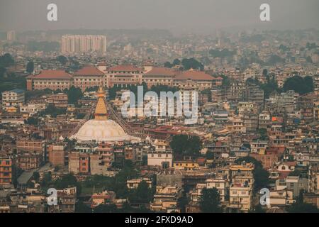Boudha Stupa circondato dalle infrastrutture della città di Kathmandu in una giornata frizzante mentre atterrano nell'aeroporto internazionale, Nepal Foto Stock