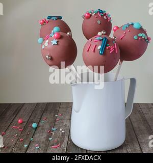 La torta al cioccolato rosa finissimo si apre con brillanti sprrinkes multicolori un vaso Foto Stock