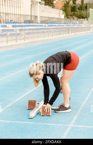 Atleta femminile con gamba protesica che prepara blocchi di partenza Foto Stock