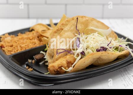 Due tipi di tacos serviti con tutti i ripieni, riso e fagioli fritti come piatto combinato. Foto Stock