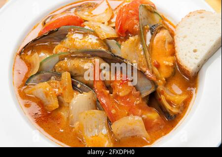 Cozze e peperoni rossi in una zuppa asiatica in un ristorante coreano. Foto Stock