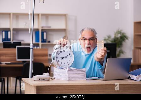 Vecchio impiegato di affari nel concetto di trasfusione di sangue Foto Stock