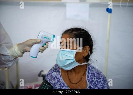 Nuova Delhi, India. 26 Maggio 2021. Un operatore sanitario prende la temperatura dalla donna nello Sri Guru Tegh Bahadar Covid-19 Medical Isolation & Treatment Center, a Gurdwara Rakab Ganj Sahib. Delhi Sikh Gurdwara Management Committee Run covid-19 centro di cura con l'aiuto di Organizzazione Internazionale per i diritti umani e il Governo di Delhi. Il 26 maggio 2021 24, 95,591 casi attivi registrati in India secondo il sito web del Ministero della Salute. (Foto di Pradeep Gaur/SOPA Images/Sipa USA) Credit: Sipa USA/Alamy Live News Foto Stock