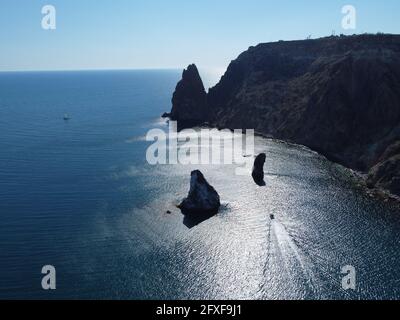 Vista aerea dall'alto sul mare azzurro e sulle coste rocciose. Piccole onde sulla superficie cristallina dell'acqua sfocata. Natura estate mare mare spiaggia Foto Stock