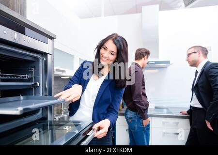 Donna forno di prelievo per la cucina domestica in studio o negozio di mobili Foto Stock