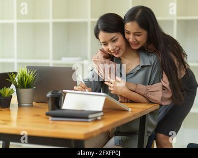 Ritratti di una coppia adorabile mentre si lavora sulla scrivania dell'ufficio nella stanza dell'ufficio domestico Foto Stock