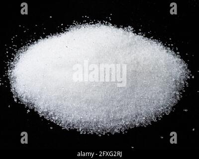 manciata di estratto cristallino di strevia zucchero vegetale sostituto closeup sulla piastra nera Foto Stock