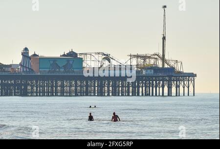 Brighton UK 27 maggio 2021 - i nuotatori si portano al mare a Brighton in una bella mattina calda e soleggiata con previsioni meteo più calde per arrivare oltre il fine settimana di vacanze in banca nel Regno Unito con temperature previste per raggiungere oltre 20 gradi nel Sud Est : Credit Simon Dack / Alamy Live News Foto Stock