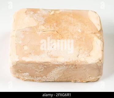 torta di lievito compressa fresca surgelata su closeup di piastra bianca Foto Stock