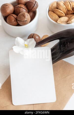 Biglietto da visita con spazio per il design e fiori vicino a noci Foto Stock