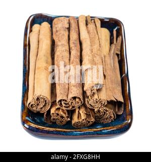 vista finale dei quills della cannella continentale di ceylon in ceramica ciotola tagliata su sfondo bianco Foto Stock